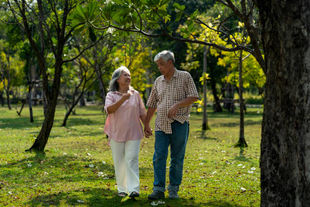 istock Romantic elderly couple holding hands looks happy in the park 2201899186