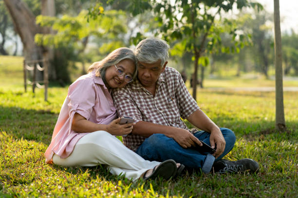 istock Happy senior couple using smartphone in public park 2201899394