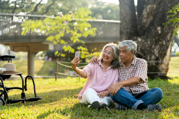 istock Happy senior couple using smartphone in public park 2201899432