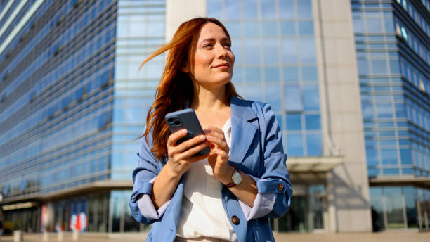 istock Stunning woman texting on her smartphone while strolling through the city 2201899652