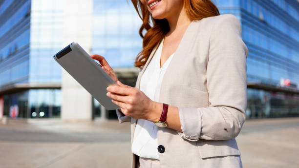 istock Happy woman using tablet on the sunny street 2201900434