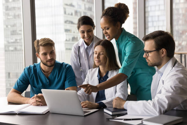 istock African medical worker explaining opinion to colleagues using laptop 2201902875