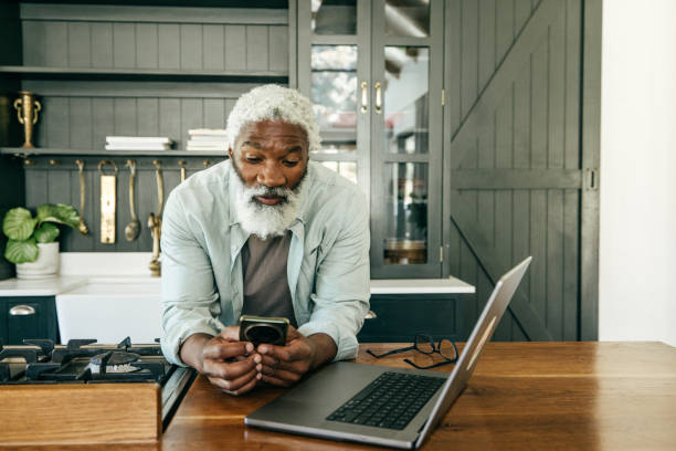 istock Managing the Numbers: Mature Man Handling Taxes from His Kitchen Table 2201910012