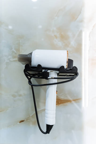 istock A white hair dryer is mounted securely and hanging on a wall, ready for use whenever someone needs to dry their hair quickly and effortlessly in the comfort of their home 2201910521
