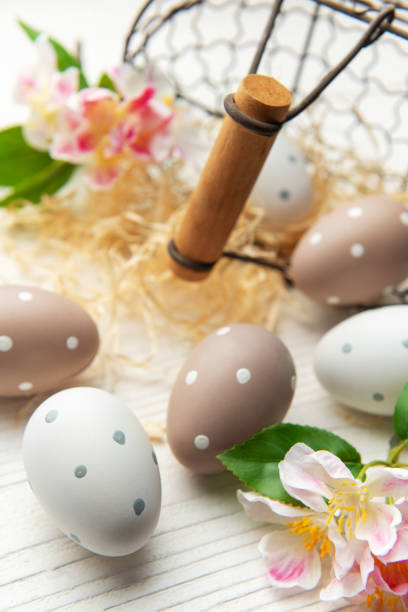 istock Easter eggs are decorating a white wooden table with raffia and flowers 2201911154