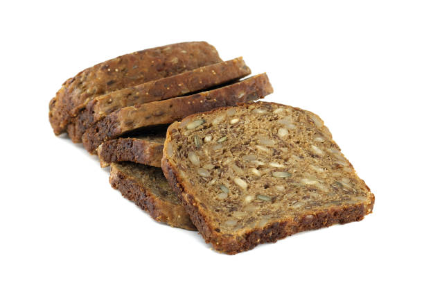 Several slices of dark multigrain bread are stacked, showing off the healthy mix of seeds.