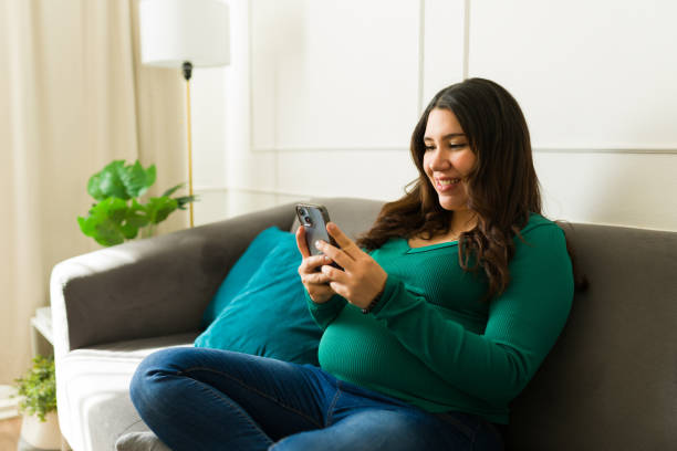 istock Happy pregnant woman using a smartphone app, enjoying relaxing time at home, browsing internet or social media 2201912472