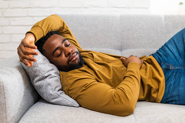 istock Peaceful nap time for tired young man on cozy sofa at home 2201917621