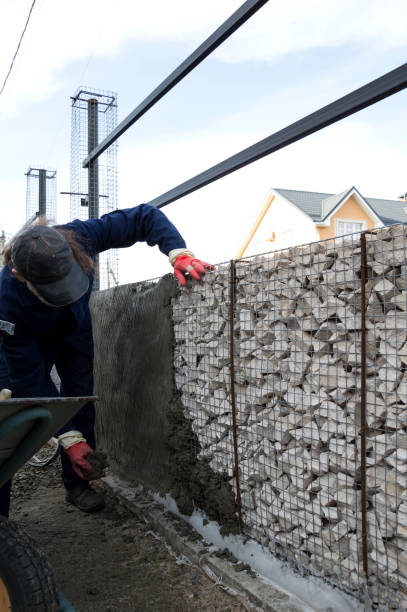 istock A worker builds a fence of stone and concrete. 2201918876