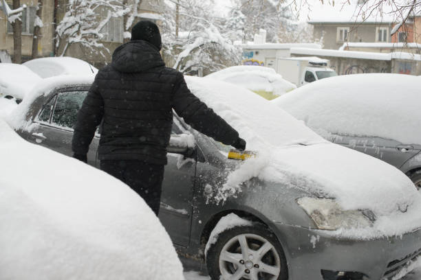 istock Man Clearing Snow From Car in Harsh Winter 2201919186