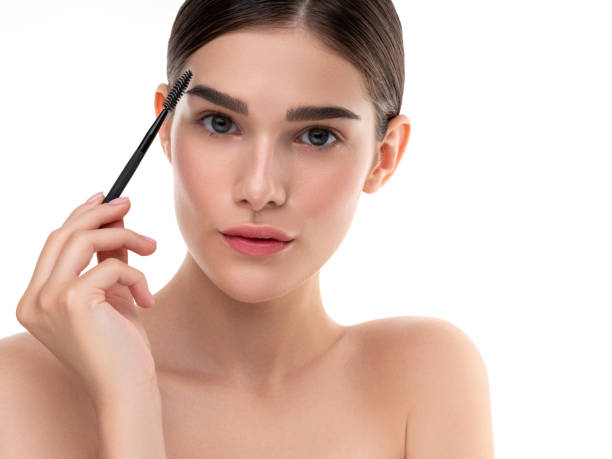 istock Young woman grooming eyebrows with brush under bright light 2201919572