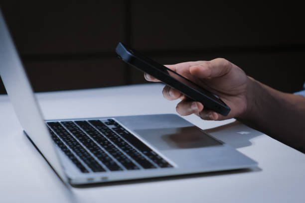 istock Cropped shot of young businessman hand typing on smartphone or laptop computer while working in office room. 2201921043