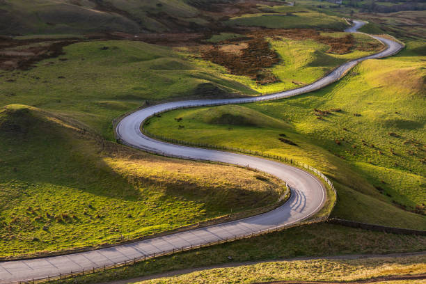 istock Winding curvy rural road leading through British countryside in The Peak District, UK. 2201923818