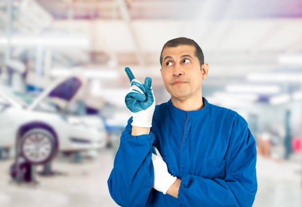 Mechanic man at repair shop.Pointing with hand and finger to the side and looking