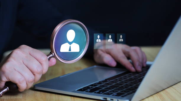istock Headhunter holding approval resume has a magnifying glass to find qualified candidates for job openings and recruitment ideas. 2201925694