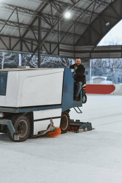 istock Ice Rink Maintenance Machine in Operation with Driver Inside Open Sports Venue 2201927014