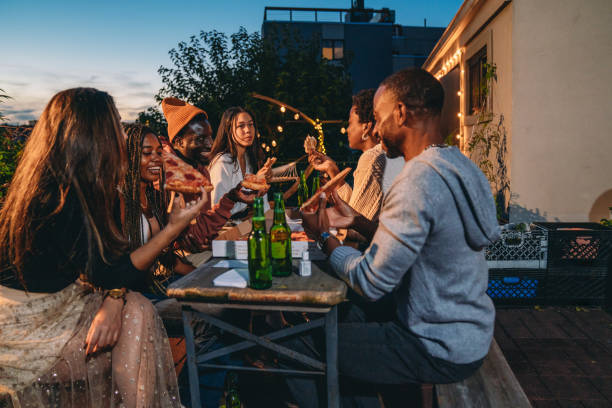 istock Dinner party with friends on a rooftop at night 2201928477
