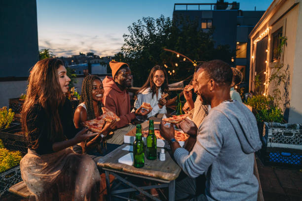 istock Dinner party with friends on a rooftop at night 2201928483