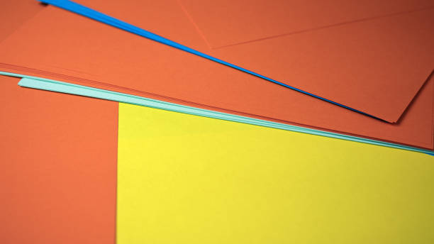 Vibrant paper sheets in orange, blue, and yellow create a lively display.