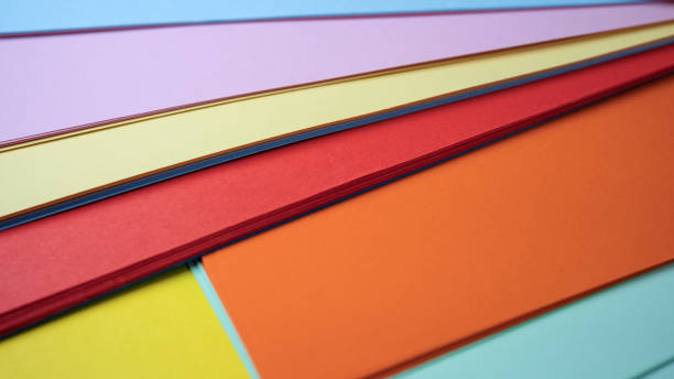 istock Colorful sheets of paper stacked in artistic arrangement on a table 2201929770