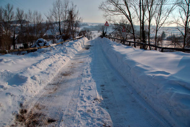 istock icy road amidst high snowdrifts ad trees 2201929833