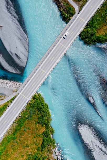 istock Top down view of car crossing a bridge over glacial river 2201930899