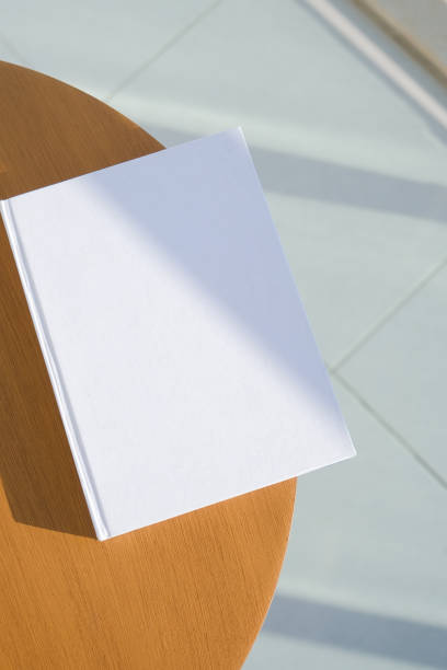 istock book cover mockup design. blank book mockup on wooden coffee table , shadow overlay 2201932837