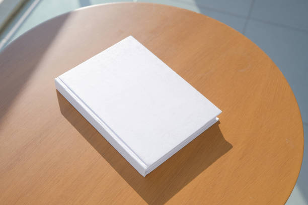 istock book cover mockup design. blank book mockup on wooden coffee table , shadow overlay 2201932862