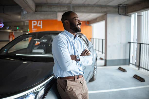 istock Confident professional smiling beside a car in a parking space 2201933020
