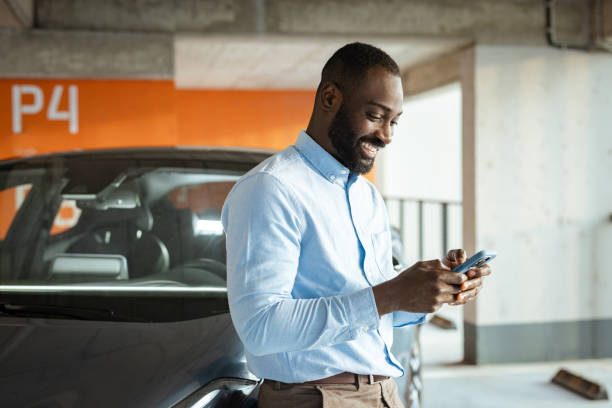istock Professional man smiling while using his smartphone in an urban parking area 2201933306