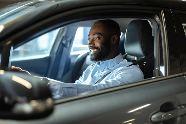 istock Man driving a car with a cheerful expression in an urban setting 2201933427