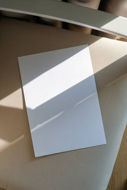 istock blank paper mockup on elegant soft armchair , shadow overlay, morning light 2201933479
