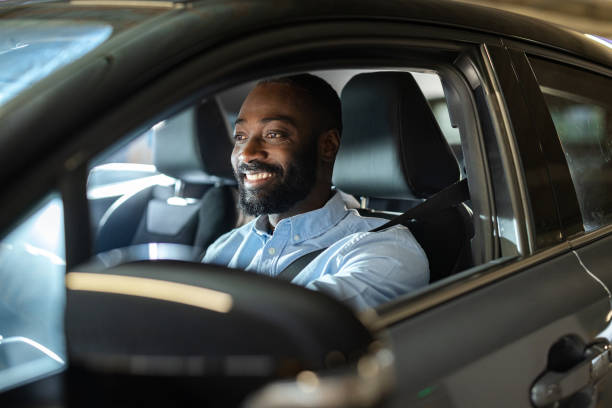 istock Man driving a car with a cheerful expression in an urban setting 2201933488