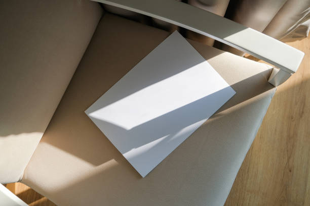 istock blank paper mockup on elegant soft armchair , shadow overlay, morning light 2201933551