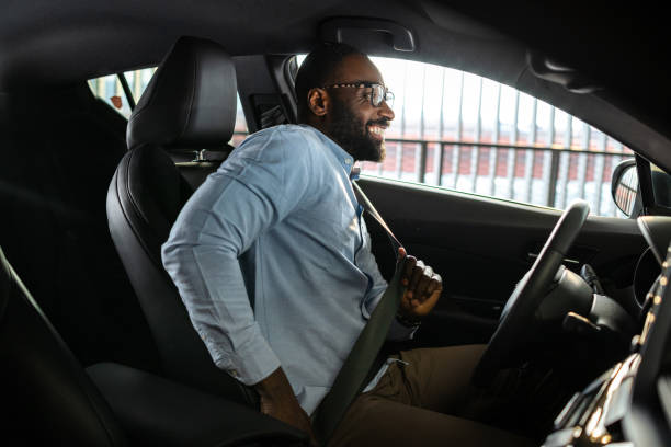istock Man fastening seatbelt inside a modern car preparing for safe driving 2201933794