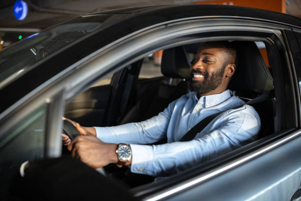 istock Smiling man confidently driving a car in an urban environment 2201933896