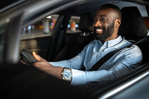 istock Smiling man confidently driving a car in an urban environment 2201933899