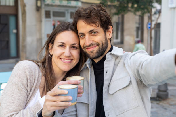 istock Happy couple taking a selfie while enjoying coffee outdoors 2201935746
