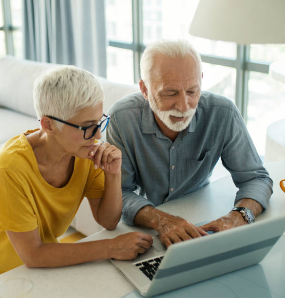Mature couple using laptop at home