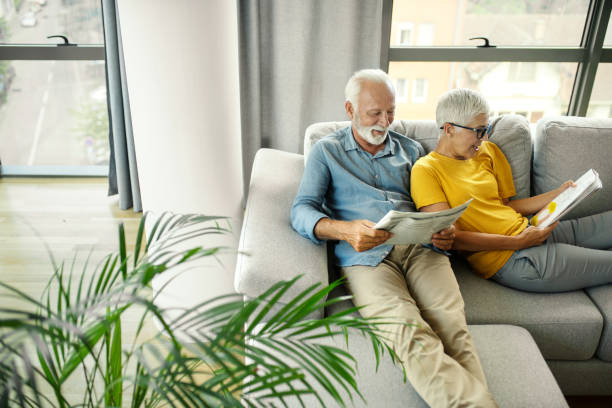 istock Mature couple reading magazines at home. 2201938843