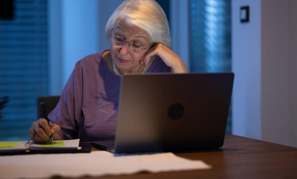 istock Senior Woman Working At Night On Laptop 2201939453