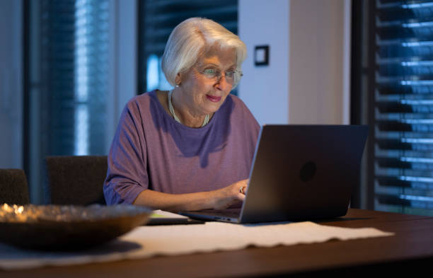 istock Senior Woman Working At Night On Laptop 2201939454