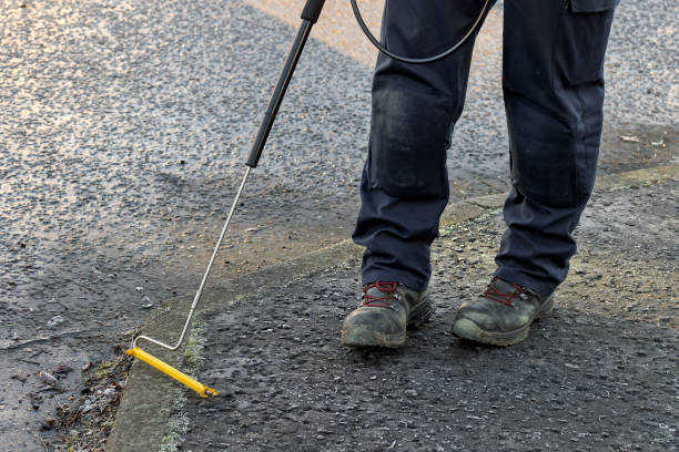 istock Gas Engineer Wearing PPE Using Long Handle Combustible Gas Leak Detector With Yellow Probe at Ground Level in City Street 2201941666