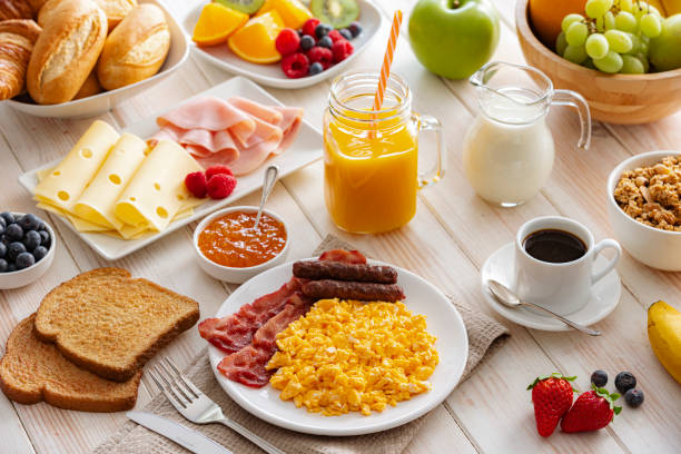 istock Breakfast table with scrambled eggs, fruits, coffee, cheese and ham 2201941714