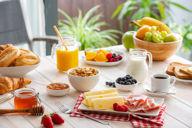 istock Breakfast table served with ham and cheese, fruits, bread, muesli and coffee 2201941715