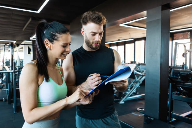 istock Dedicated Woman Gearing Up for Workout with Personal Trainer 2201942237