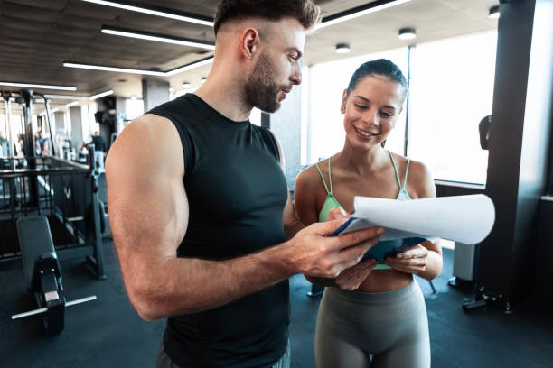 istock Personal Trainer Guiding Young Woman Through Warm-Up 2201942296