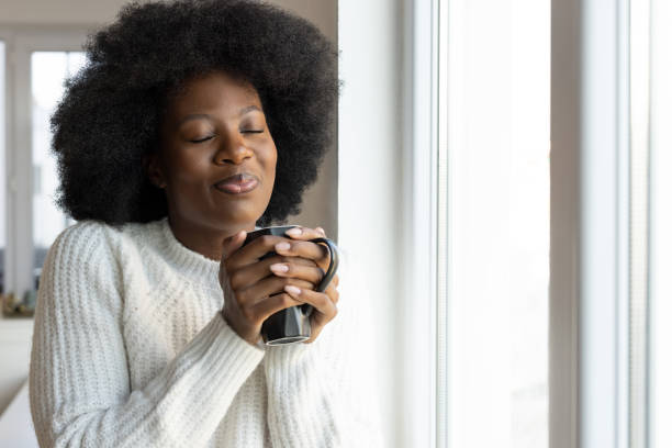 istock Happy woman drinking hot drink 2201946220
