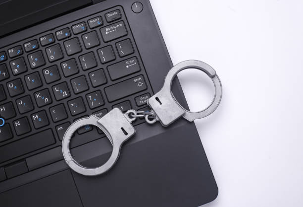 istock Laptop with handcuffs on white background. Cyber police 2201946561
