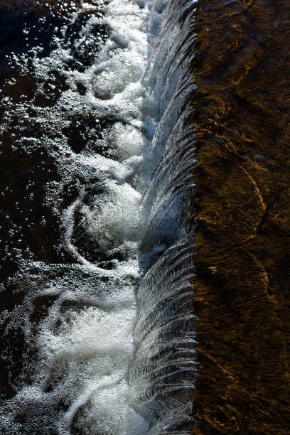 istock Waterfall view from above. Falling water, foam from the waterfall. Winter 2201948927